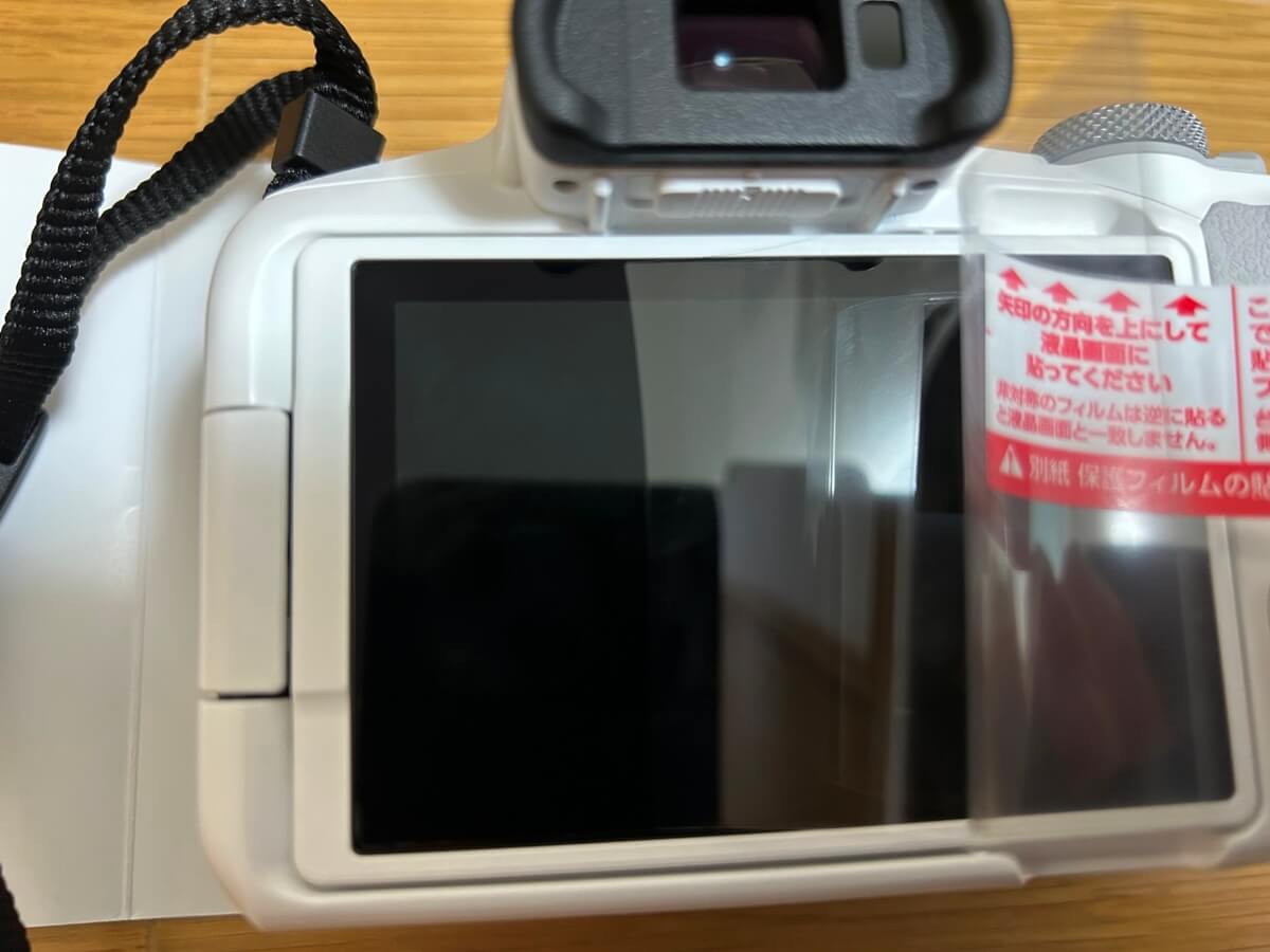 液晶保護フィルムをカメラの液晶画面へ貼りつけていく